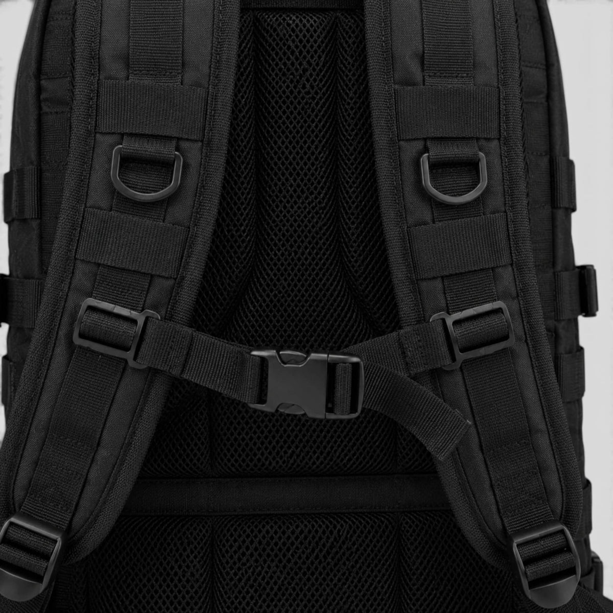 Close-up of subdued American flag patch and MOLLE webbing on front pocket of black tactical travel bag

