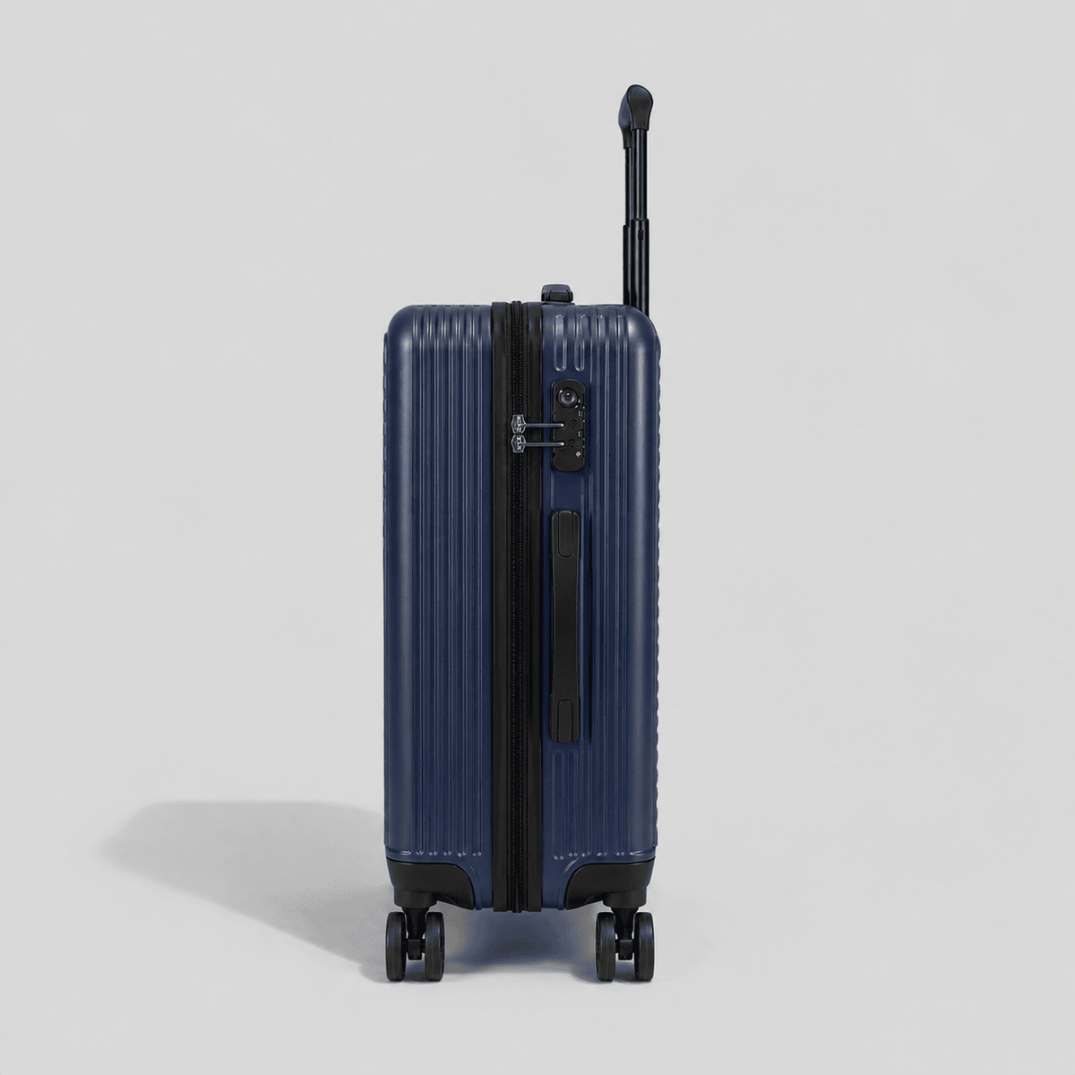 Side profile of navy blue hardshell carry on luggage showing TSA combination lock, perimeter zipper pull, and black wheel base

