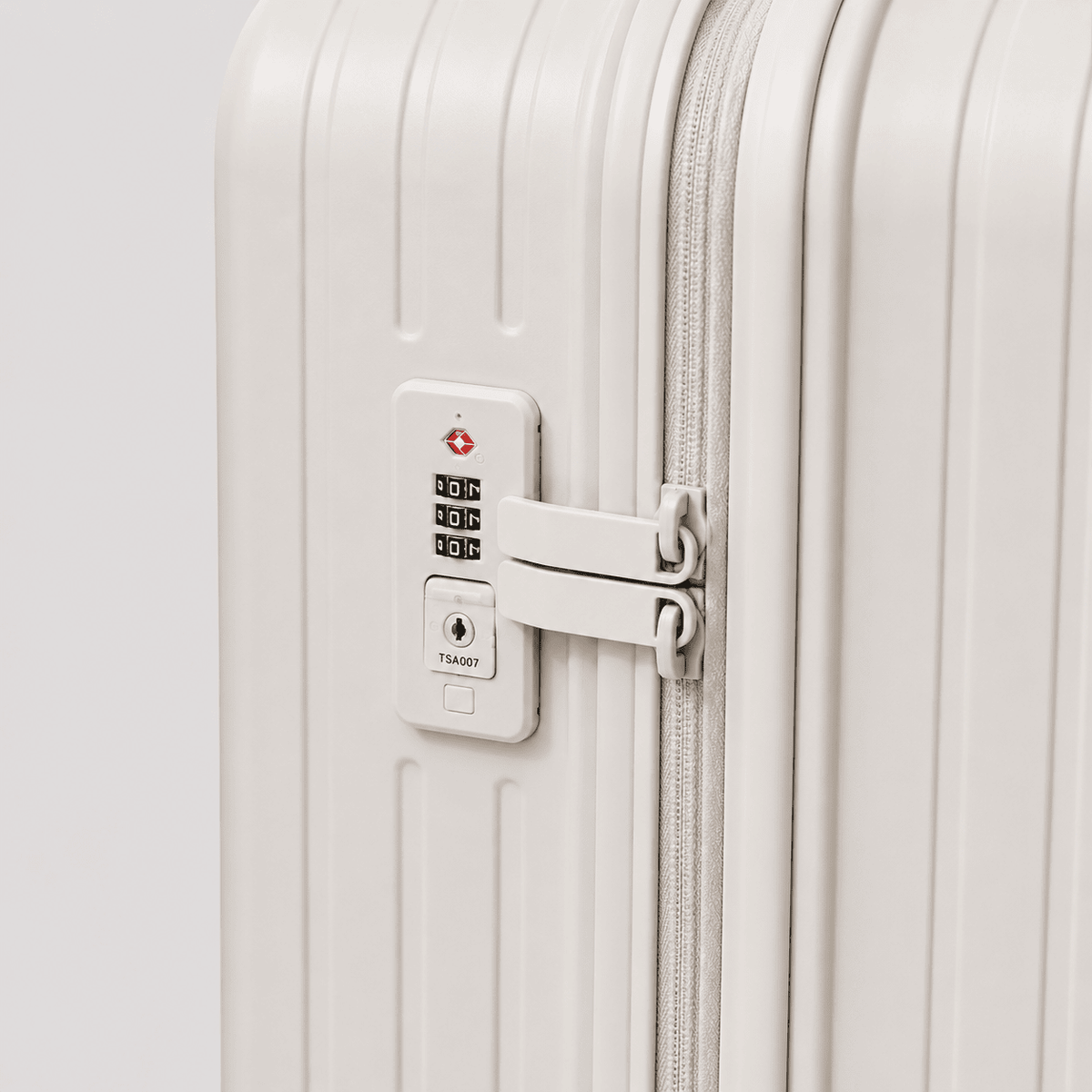 Close-up of a white roamio atlas with a TSA-approved lock on a light gray background