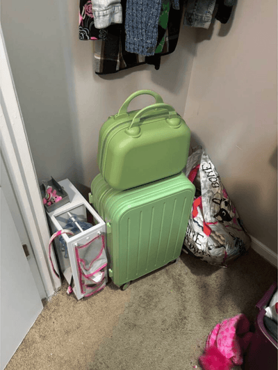 Green roamio atlas in a small room with clothes and bags on the floor.