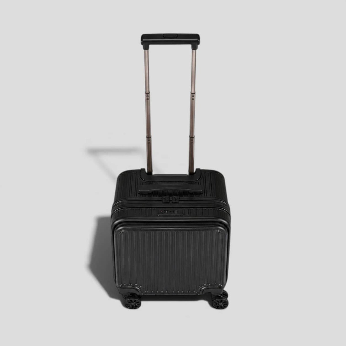 Top down view. Black onyx hardshell small carry on luggage with extended telescoping handle, ribbed exterior, 360 spinner wheels, and front zip pocket