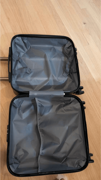Open black suitcase on a wooden floor