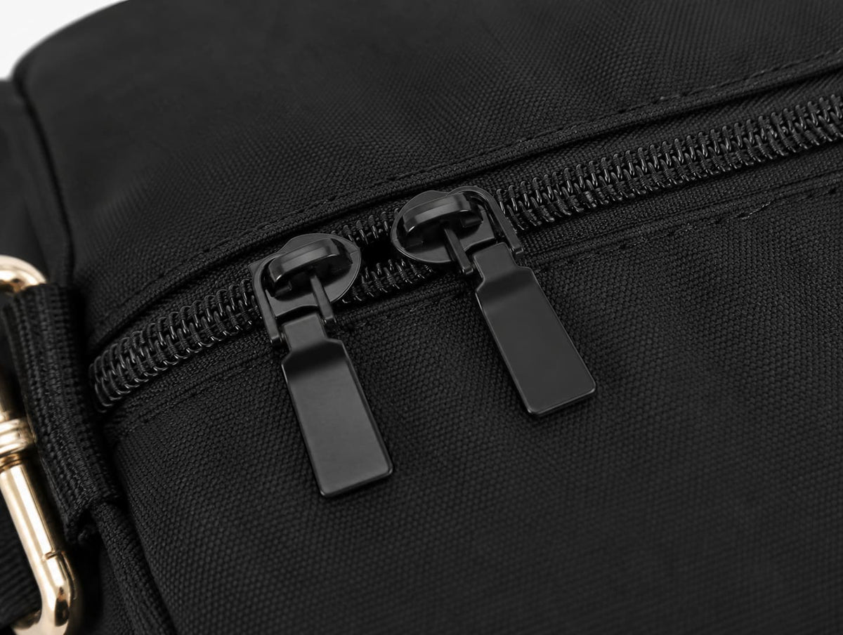Close-up of silver metal D-ring and swivel clip on the adjustable shoulder strap of a black canvas duffel bag
